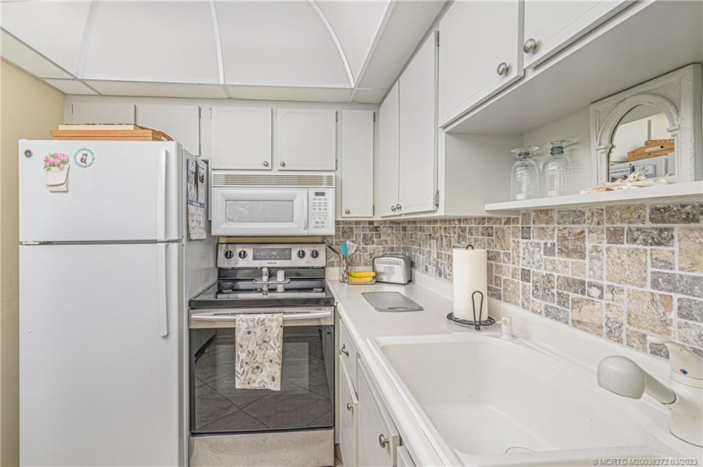 2929 Southeast Ocean Boulevard, Unit 1436 Stuart, FL 34996 - Photo 7 of 18 a kitchen with a sink a stove and refrigerator