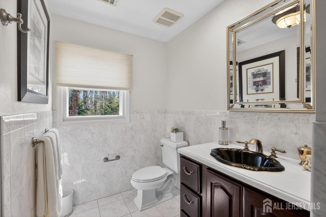 15 Cherokee Road East Brunswick, NJ 08816 - Photo 21 of 45 a bathroom with a sink a toilet and a mirror