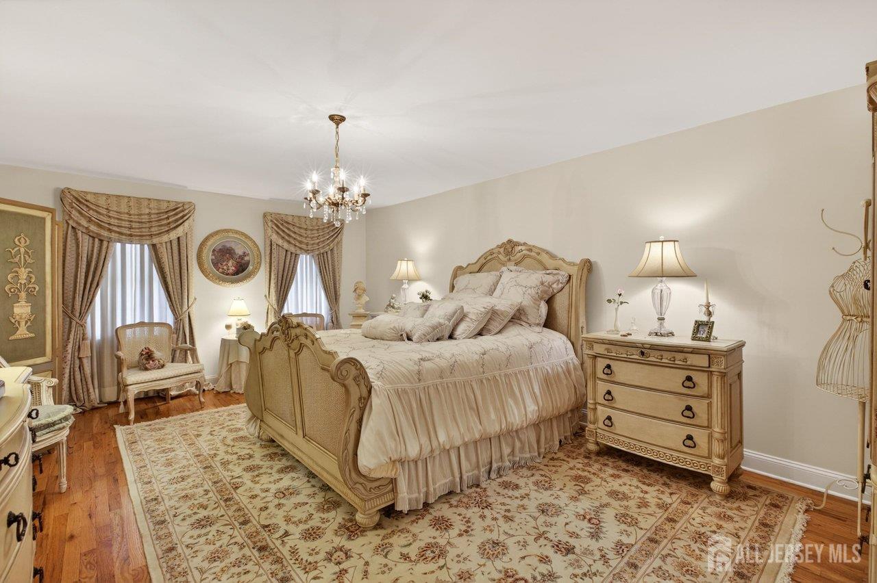 15 Cherokee Road East Brunswick, NJ 08816 - Photo 23 of 45 a spacious bedroom with a bed and a chandelier
