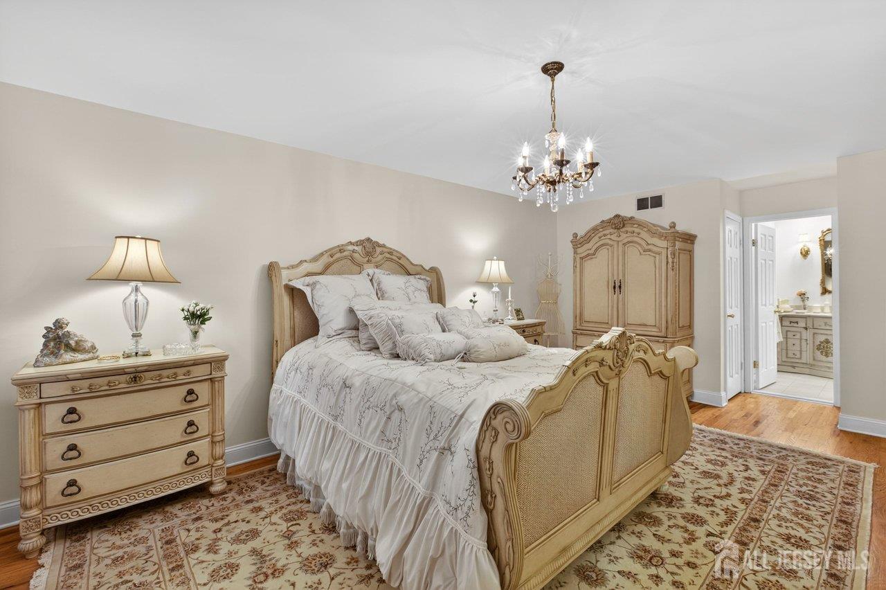 15 Cherokee Road East Brunswick, NJ 08816 - Photo 24 of 45 a bed room with a bed and a chandelier