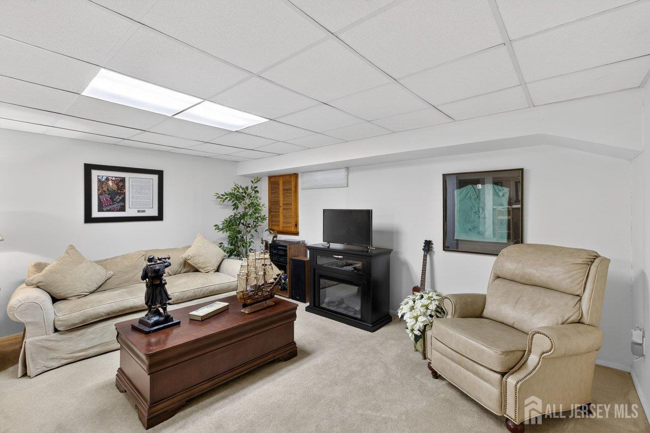 15 Cherokee Road East Brunswick, NJ 08816 - Photo 32 of 45 a living room with furniture and a flat screen tv