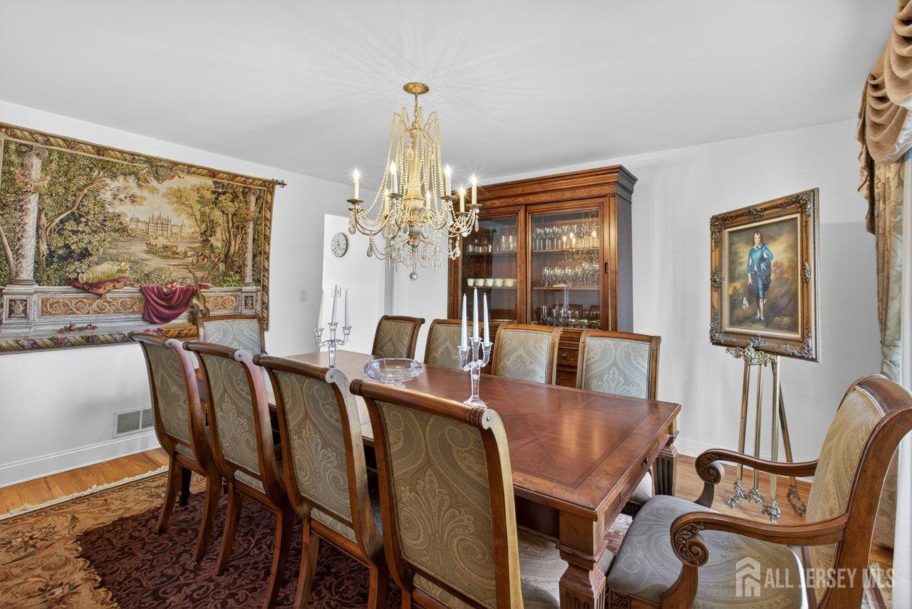 15 Cherokee Road East Brunswick, NJ 08816 - Photo 10 of 45 a view of a dining room with furniture a chandelier and wooden floor