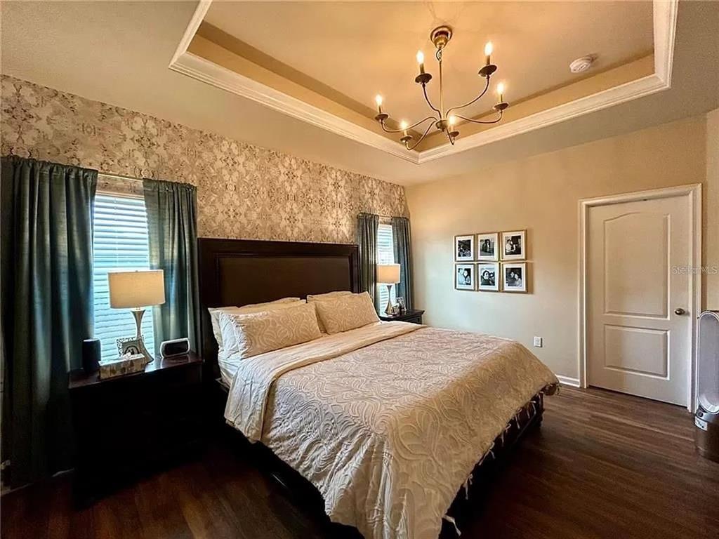 9883 Northwest 17th Road Gainesville, FL 32606 - Photo 7 of 11 a bedroom with a bed and a chandelier