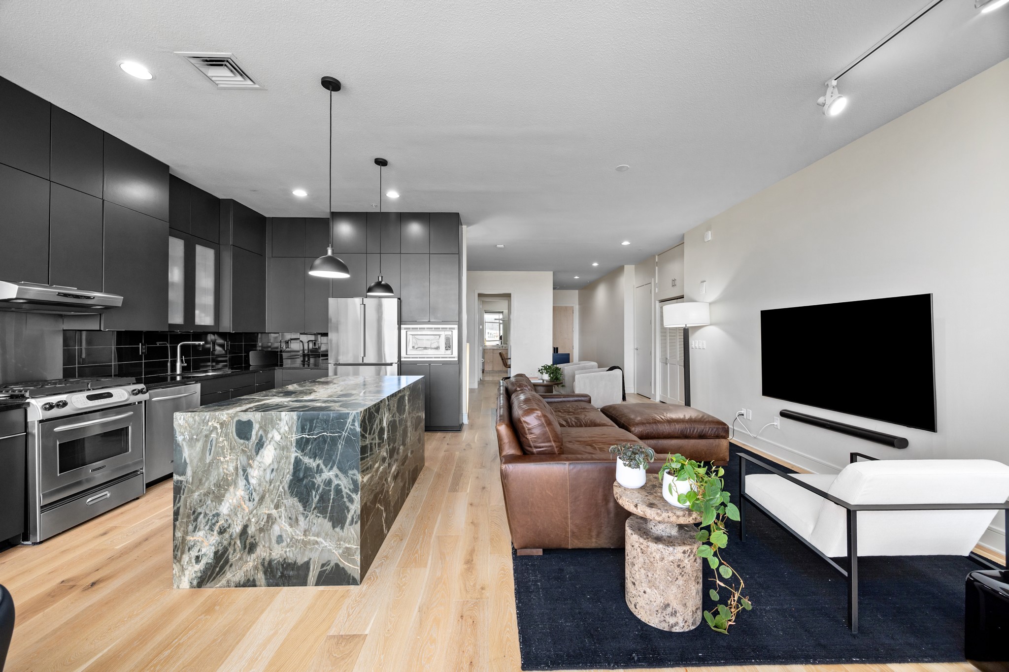 555 East 5th Street, Unit 521 Austin, TX 78701 - Photo 11 of 37 a large living room with stainless steel appliances kitchen island granite countertop a couch and a view of living room