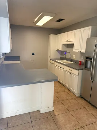 a kitchen with a sink a stove top oven and cabinetry