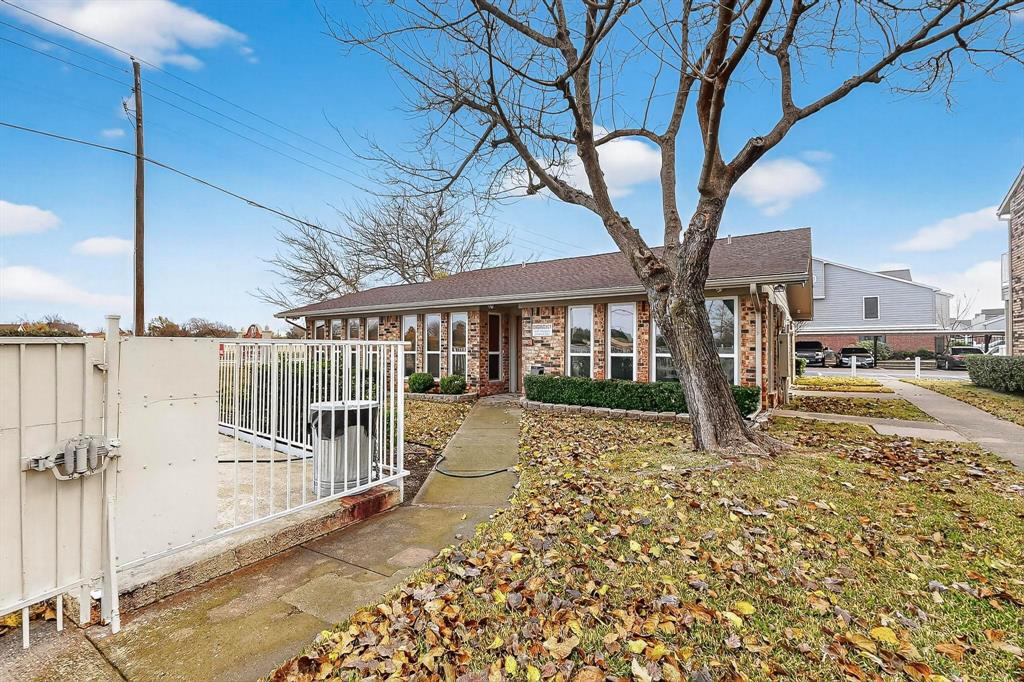 2200 East Trinity Mills Road, Unit 616 Carrollton, TX 75006 - Photo 32 of 34 a view of a house with a large tree and wooden fence