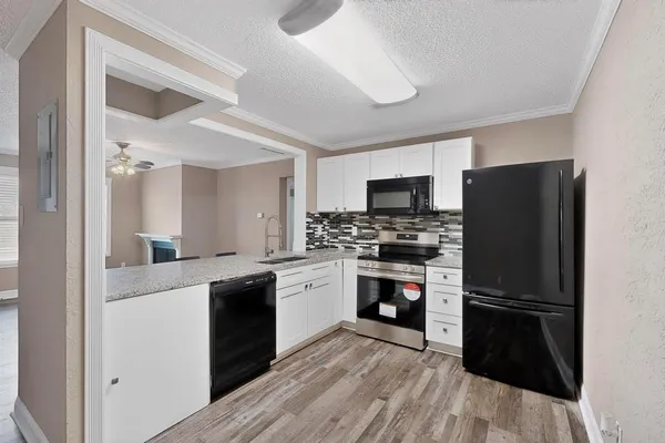 a kitchen with granite countertop a sink and a stove top oven