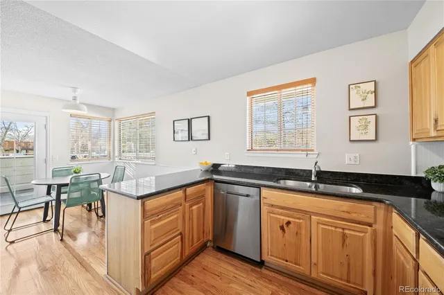 a kitchen with granite countertop a sink and white cabinets
