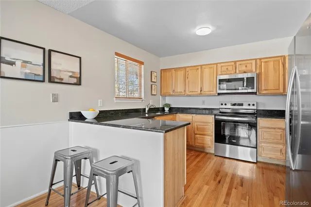 a kitchen with granite countertop a stove a sink and a microwave