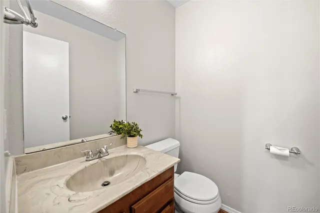 a bathroom with a sink vanity mirror and toilet