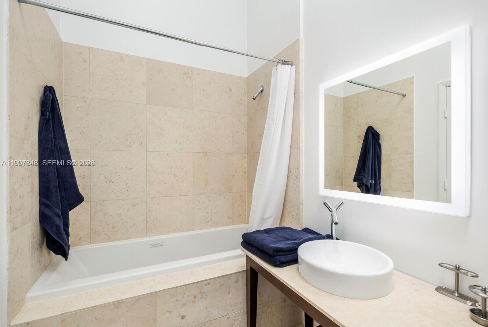 475 Brickell Avenue, Unit 2811 Miami, FL 33131 - Photo 14 of 14 a bathroom with a granite countertop sink and a mirror