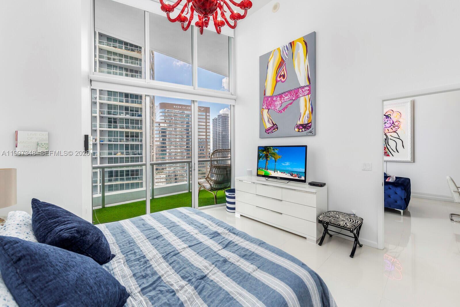 475 Brickell Avenue, Unit 2811 Miami, FL 33131 - Photo 9 of 14 a bedroom with a bed a dresser and a large mirror