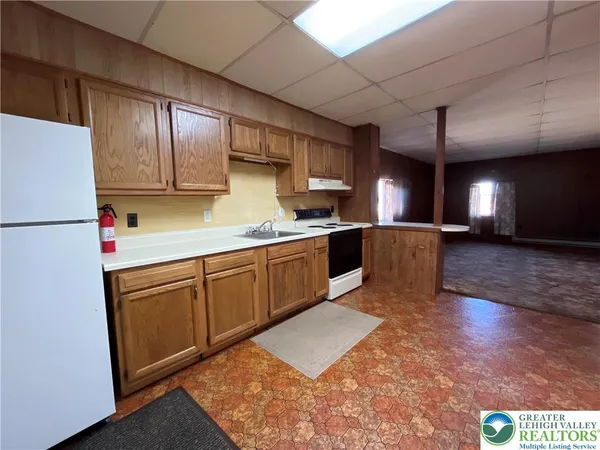 a kitchen with stainless steel appliances granite countertop a refrigerator a sink dishwasher a stove with wooden cabinets