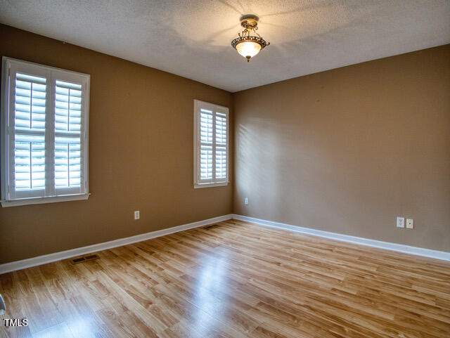 2817 Buckboard Lane Raleigh, NC 27603 - Photo 20 of 31 an empty room with wooden floor and windows