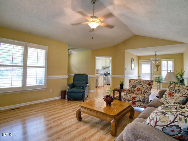 2817 Buckboard Lane Raleigh, NC 27603 - Photo 7 of 31 a living room with furniture and a chandelier