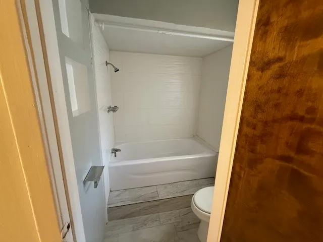 a bathroom with a bathtub and toilet