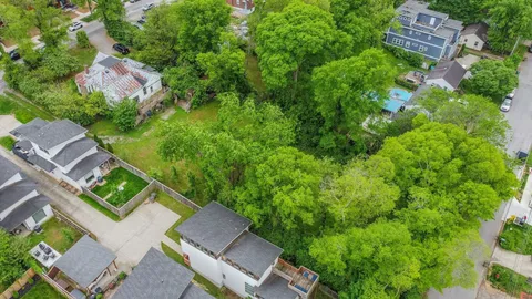 an aerial view of residential house with outdoor space and trees all around
