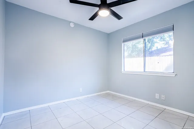 an empty room with a ceiling fan and carpet