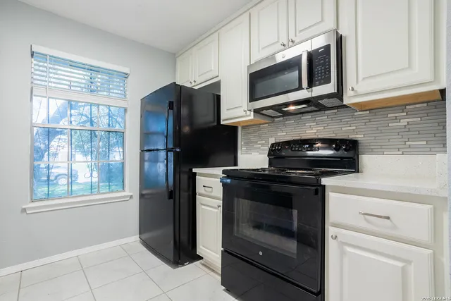 a kitchen with stainless steel appliances granite countertop a stove microwave and refrigerator