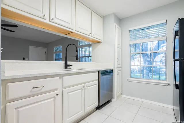 a sink with white cabinets