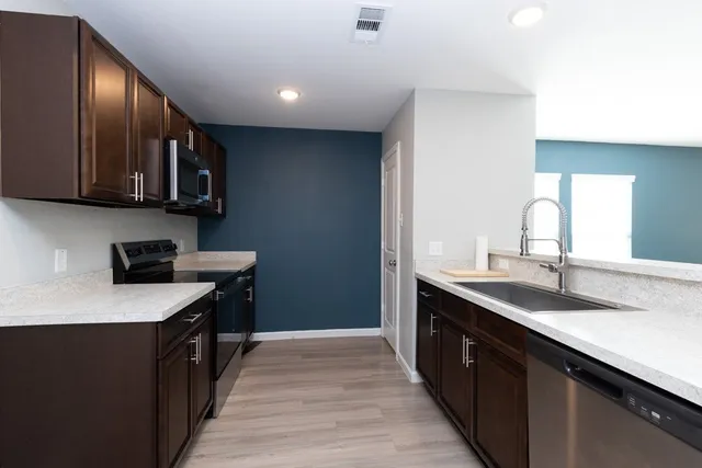 a kitchen with a sink a microwave and refrigerator
