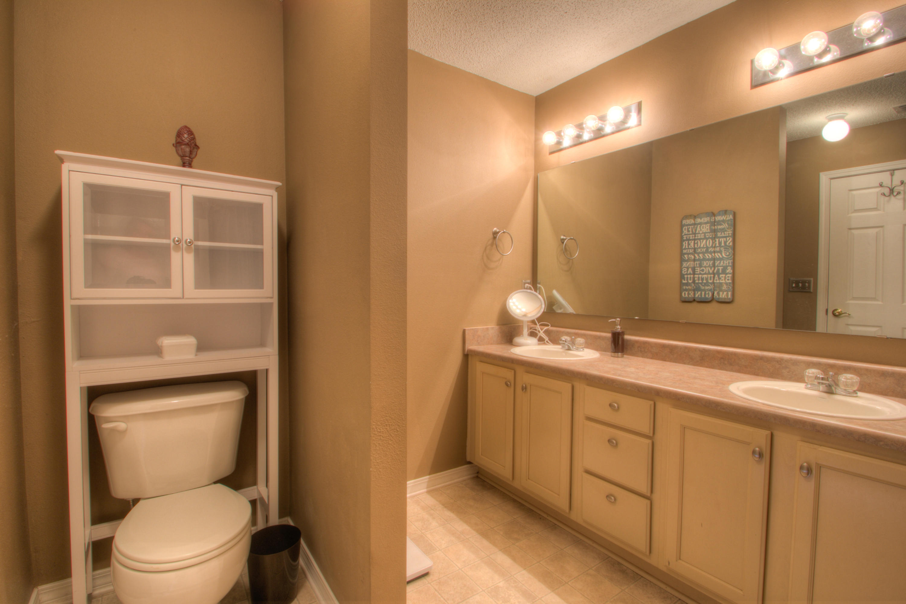 219 Limestone Circle Crestview, FL 32539 - Photo 19 of 31 a spacious bathroom with a toilet a sink and mirror