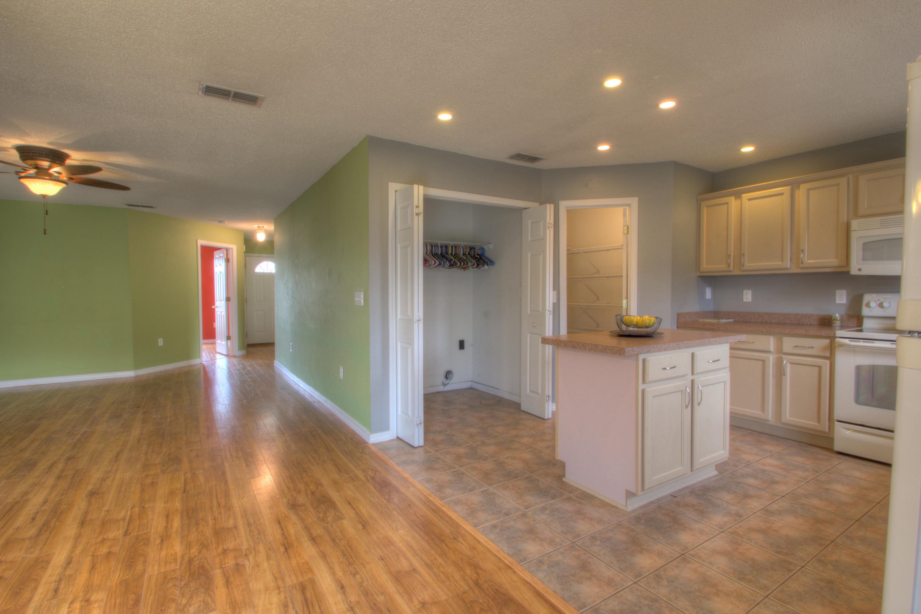 219 Limestone Circle Crestview, FL 32539 - Photo 9 of 31 a open kitchen with white cabinets and wooden floor