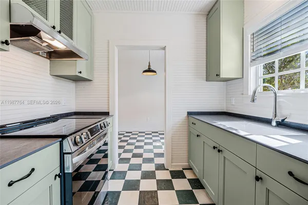 a kitchen with stainless steel appliances granite countertop a sink and a stove
