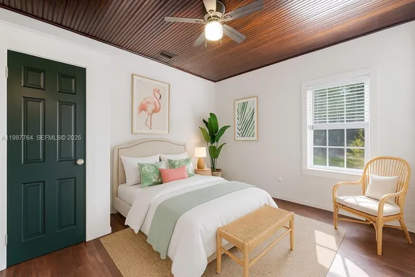 a bedroom with a bed and wooden chair