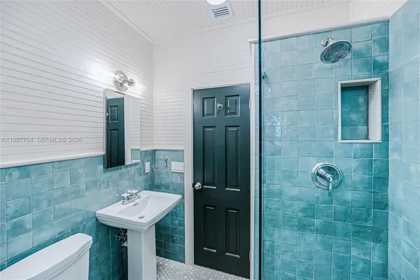 a bathroom with a sink a toilet and shower