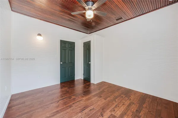 a view of empty room with wooden floor