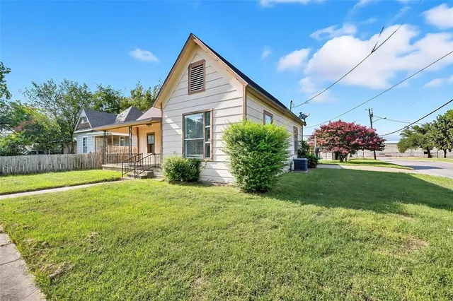a view of a house with a yard and potted plants