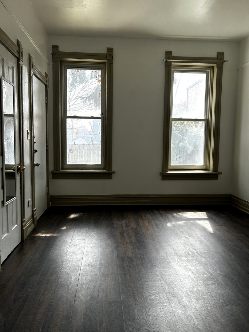 2744 West 23rd Street Chicago, IL 60608 - Photo 6 of 7 an empty room with wooden floor and windows