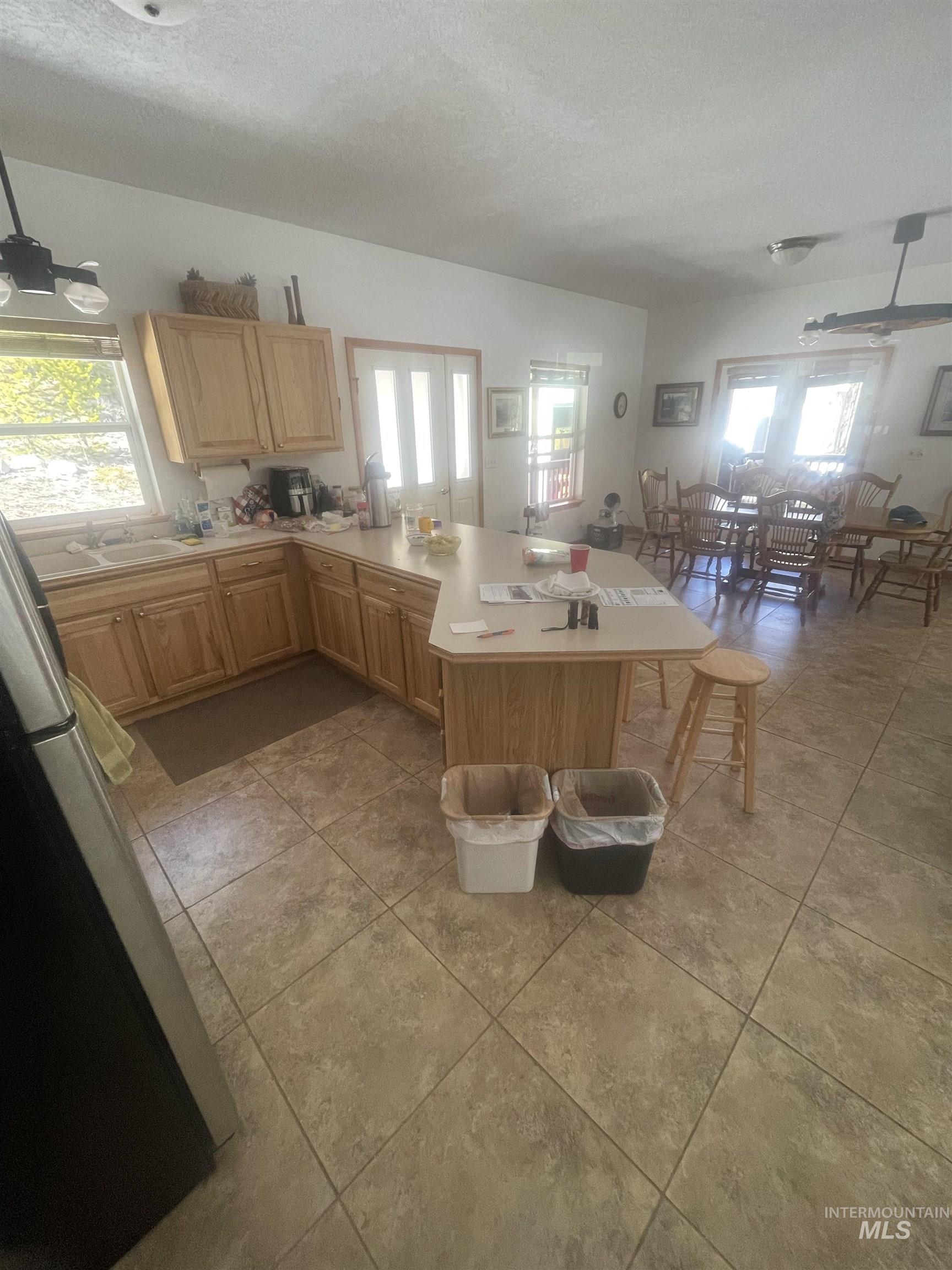 17567 Edwardsburg Road Yellow Pine, ID 83677 - Photo 8 of 11 Kitchen featuring wood cabinetry, an island with countertop seating, and tile flooring