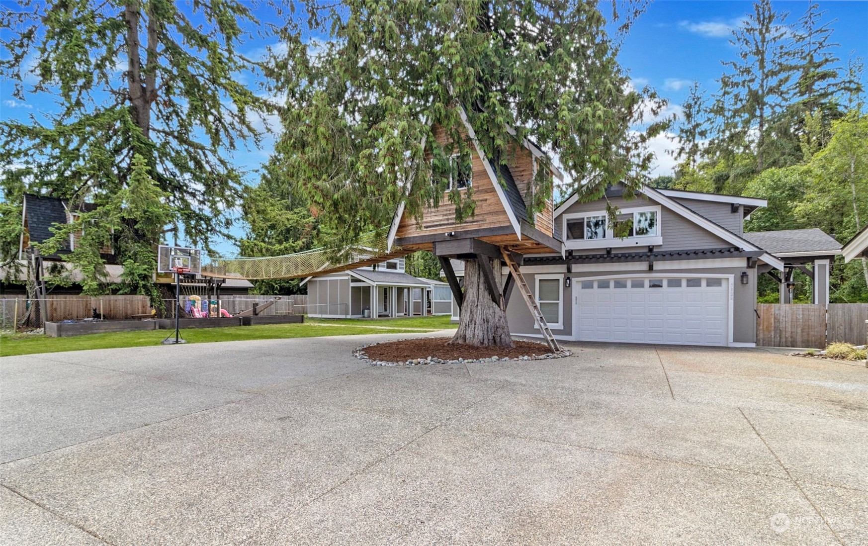5124 Schwarzmiller Road Lake Stevens, WA 98258 - Photo 4 of 32 a view of a house with large trees and wooden fence
