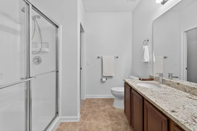 a bathroom with a granite countertop sink toilet and shower
