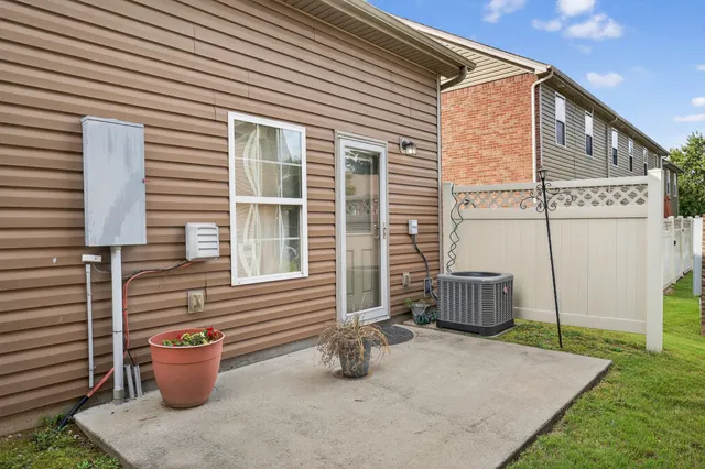 a backyard of a house with barbeque oven table and chairs