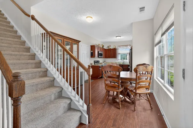 a dining room with furniture entryway and wooden floor
