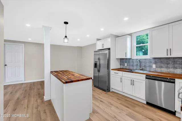 a kitchen with stainless steel appliances granite countertop a sink and a refrigerator