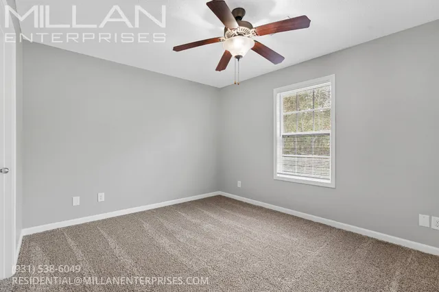 an empty room with a window and a fan