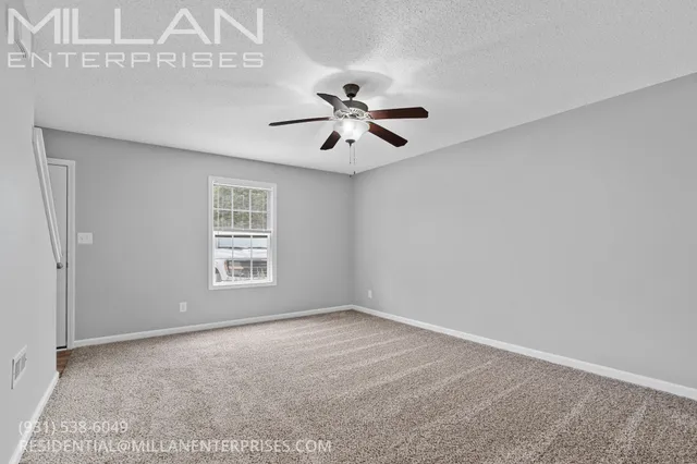 a view of a room with a ceiling fan and a window