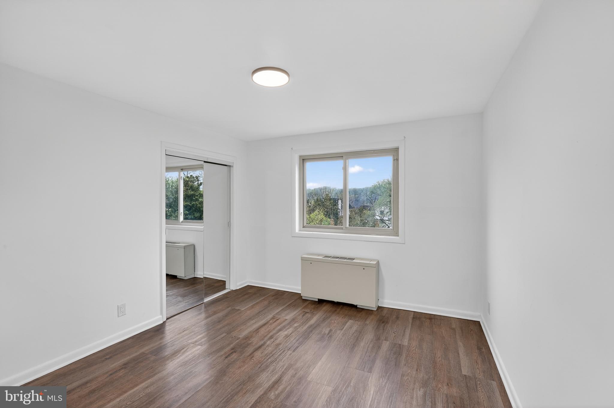 4570 MacArthur Boulevard Northwest, Unit 208 Washington, DC 20007 - Photo 12 of 17 an empty room with wooden floor and windows