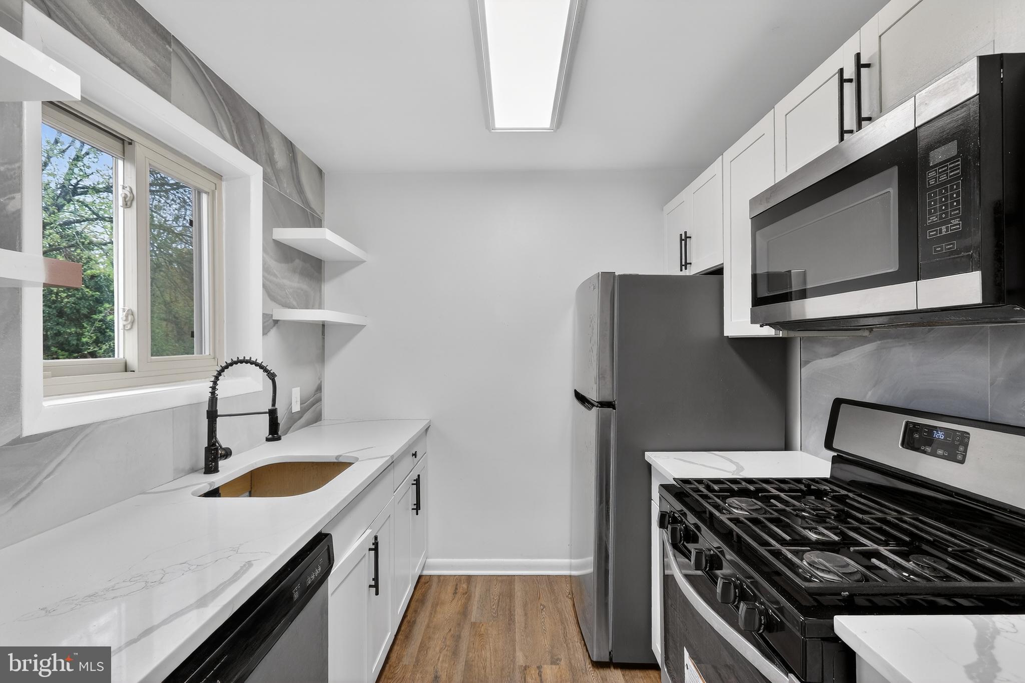 4570 MacArthur Boulevard Northwest, Unit 208 Washington, DC 20007 - Photo 2 of 17 a kitchen with granite countertop a stove and a sink