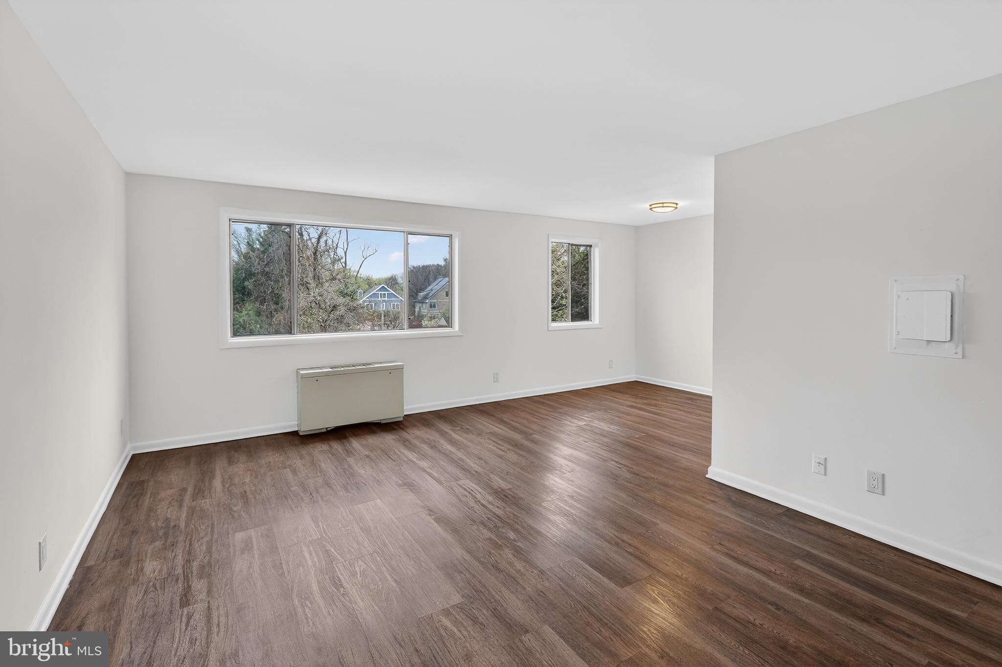 4570 MacArthur Boulevard Northwest, Unit 208 Washington, DC 20007 - Photo 7 of 17 a view of an empty room with wooden floor and a window