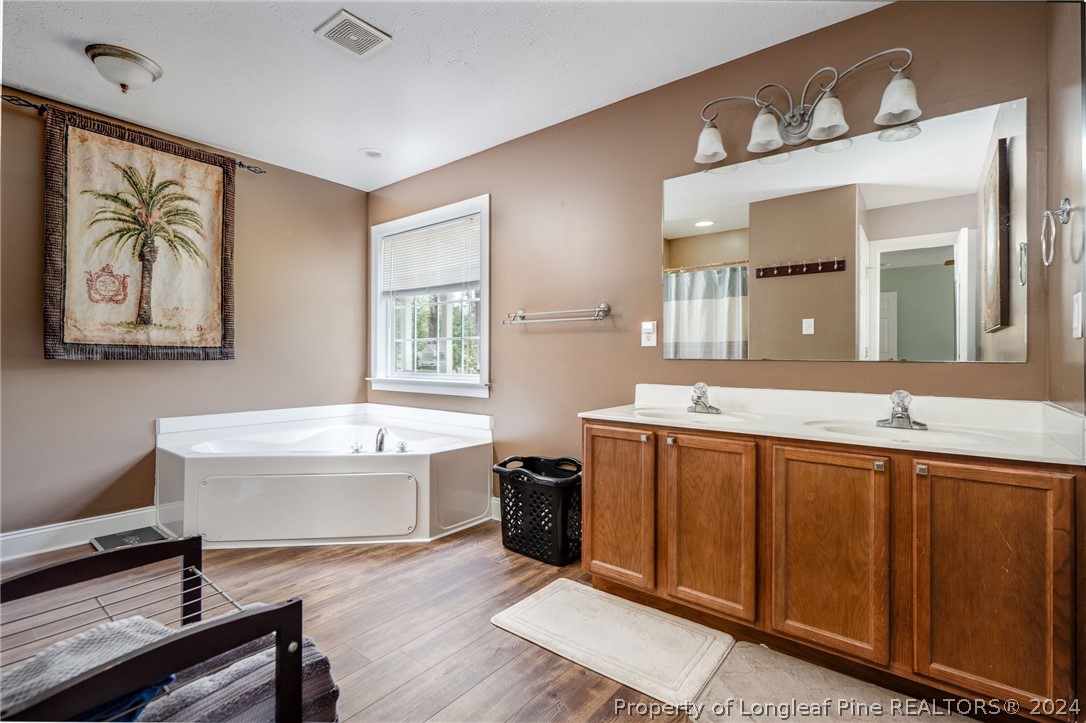 3590 Calloway Road Raeford, NC 28376 - Photo 17 of 44 a spacious bathroom with a double vanity sink a mirror and a bathtub