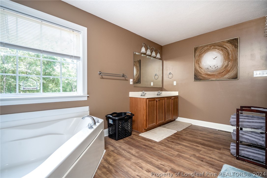 3590 Calloway Road Raeford, NC 28376 - Photo 21 of 44 a bathroom with a sink a bathtub and a window