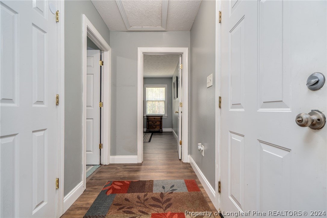 3590 Calloway Road Raeford, NC 28376 - Photo 23 of 44 a view of a hallway with wooden floor and a bathroom