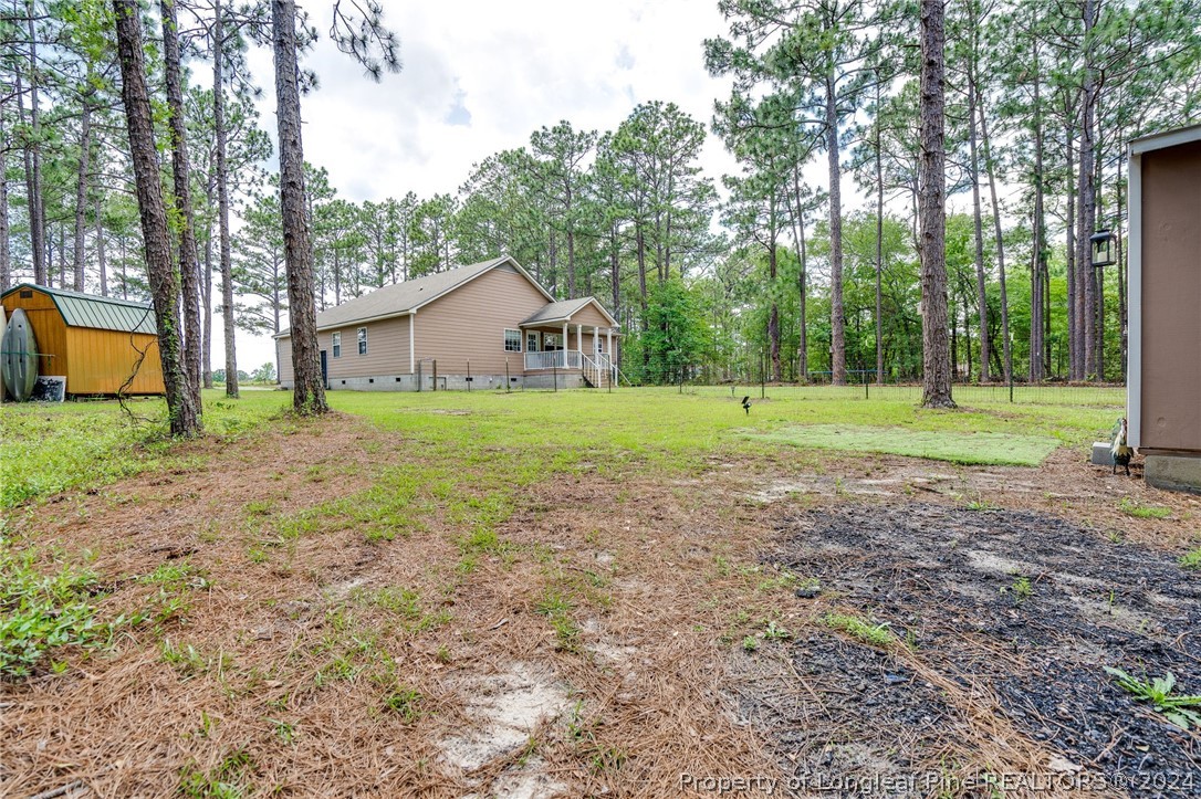 3590 Calloway Road Raeford, NC 28376 - Photo 35 of 44 a view of a big house with a big yard and large trees