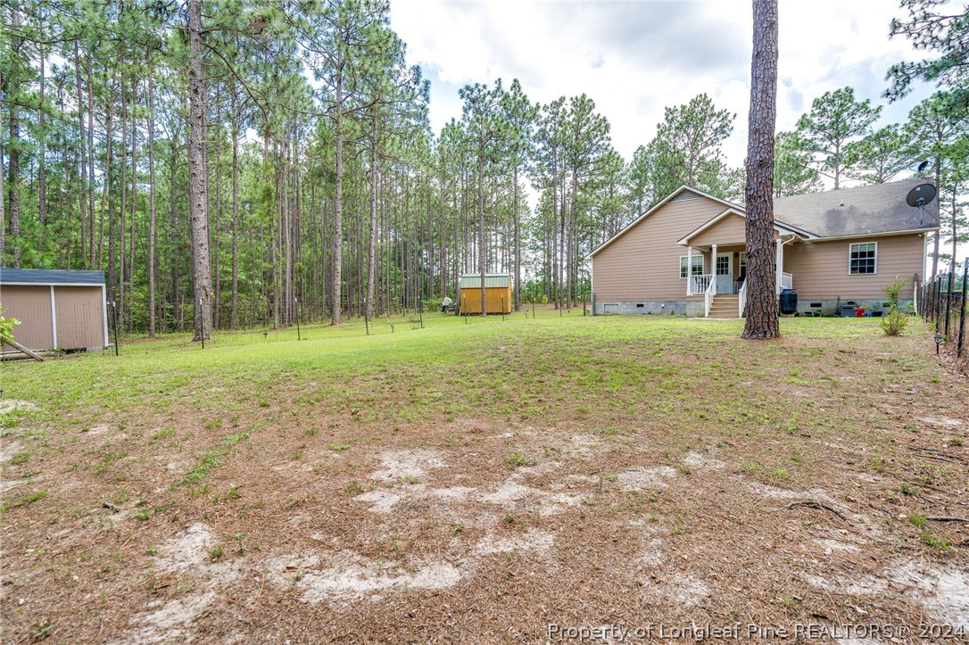 3590 Calloway Road Raeford, NC 28376 - Photo 38 of 44 a blue house with a big yard and large trees