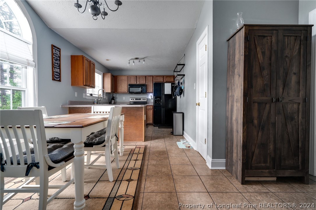 3590 Calloway Road Raeford, NC 28376 - Photo 6 of 44 a kitchen with stainless steel appliances a sink a stove a refrigerator cabinets and a dining table